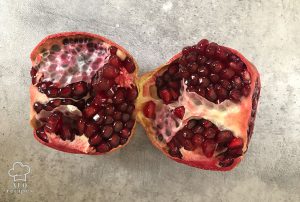 Cut each pomegranate in half